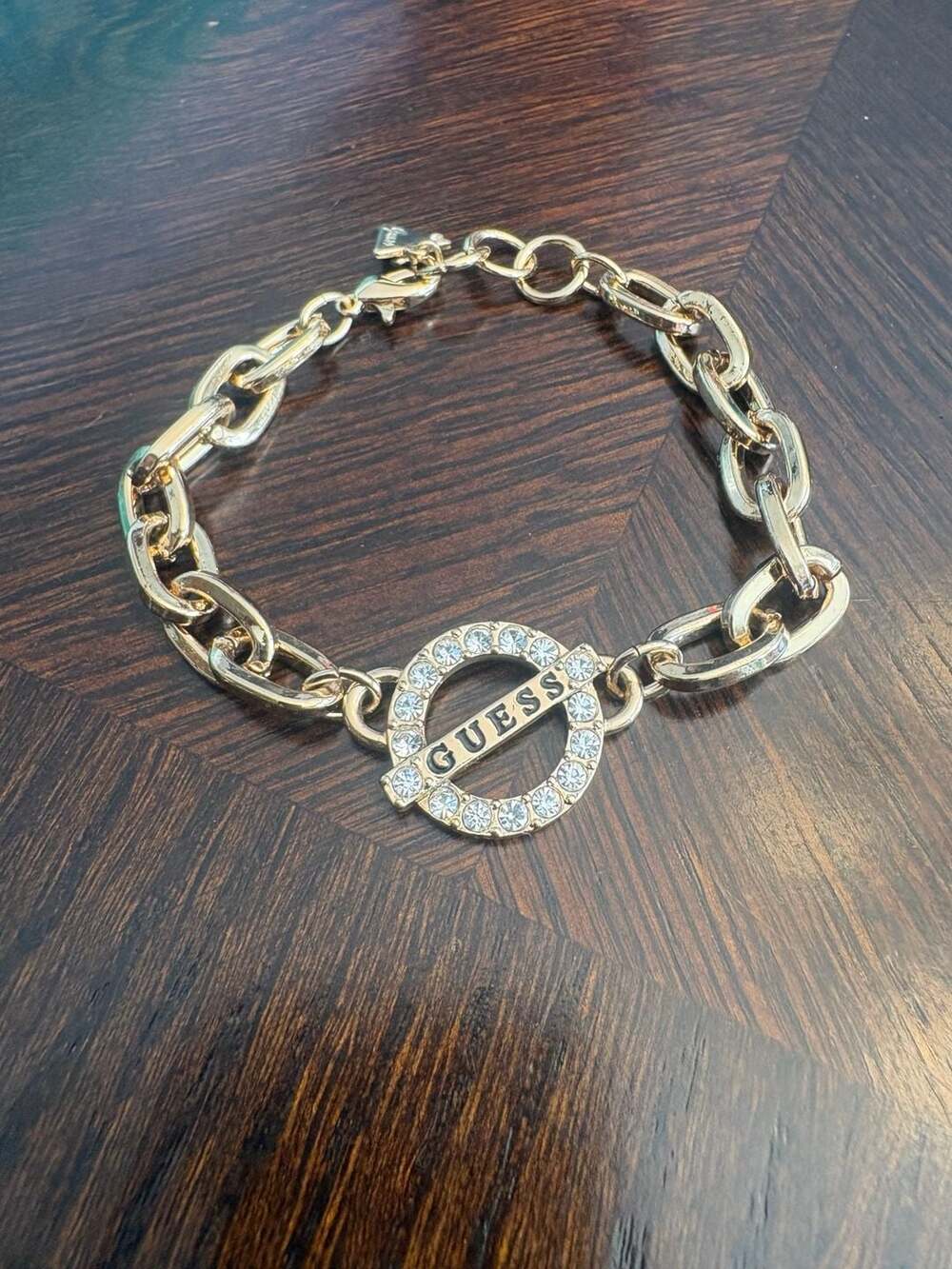 GUESS Gold Tone Charm Bracelet with Crystal Accents and Logo Charms